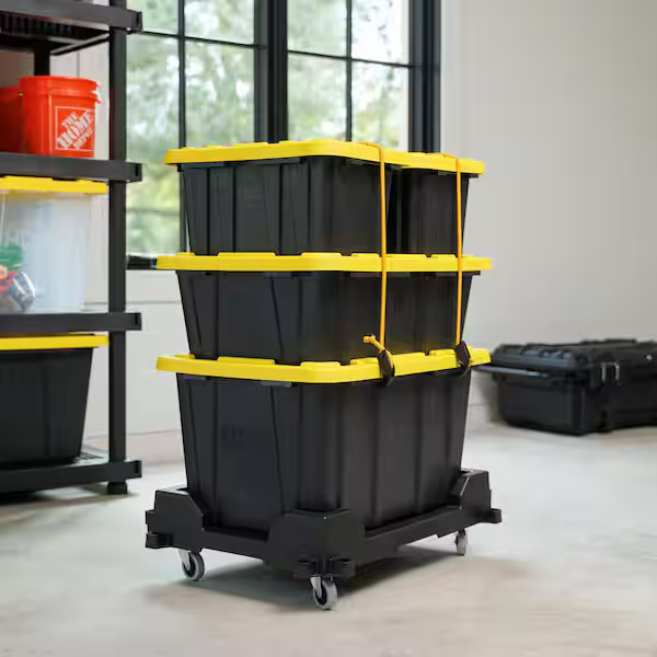 Stack of reusable moving bins strapped to a rolling dolly in a Franklin TN garage